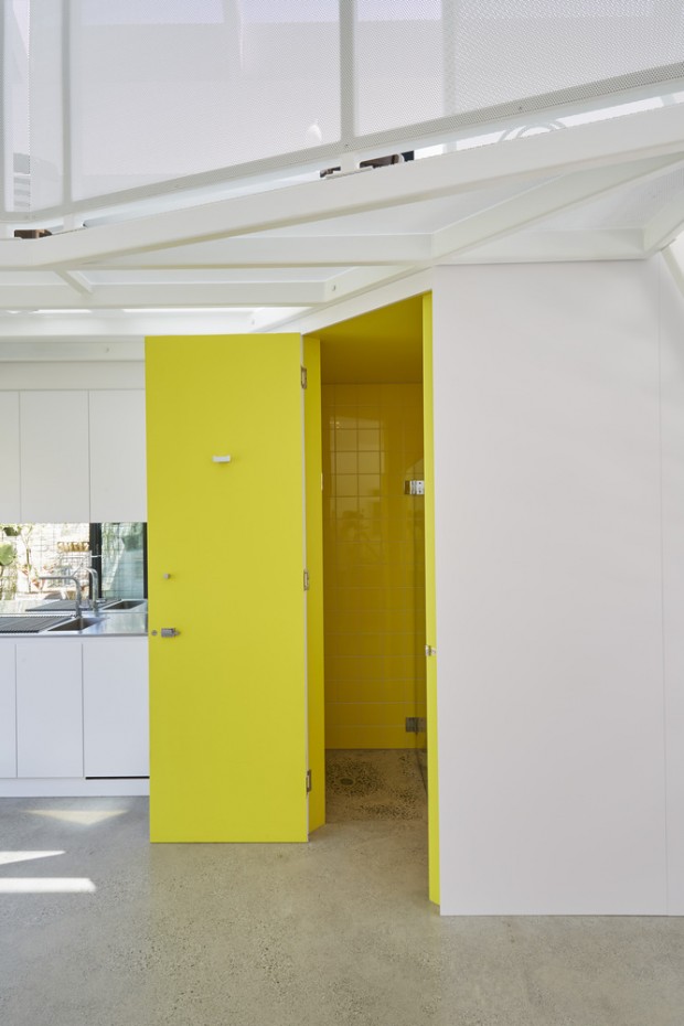 ประตูสีเหลืองสดตัดกับผนังขาว