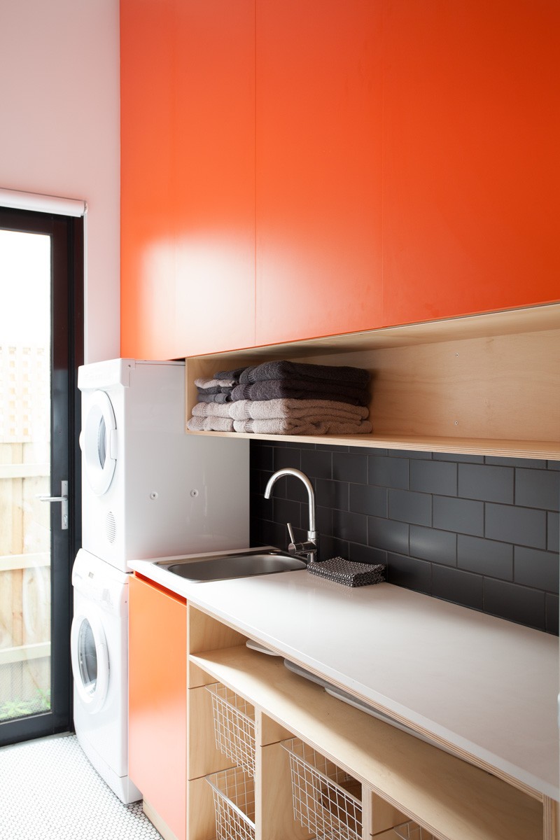 ตู้ครัวบวิท์หน้าบานสีส้มตัดกับ splash back สีดำ